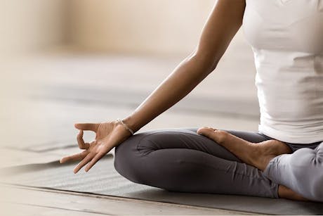 Woman in a yoga pose participating in a workplace wellness program